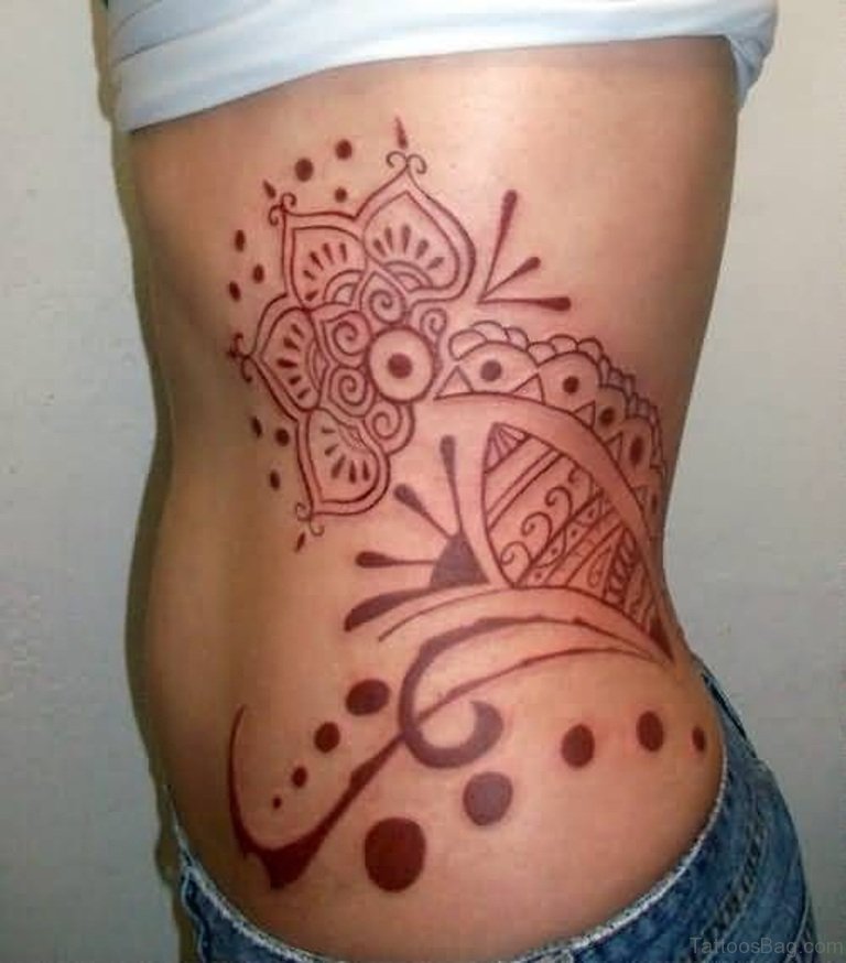 Red Ink Tribal Feminine Tattoo On Rib Side.